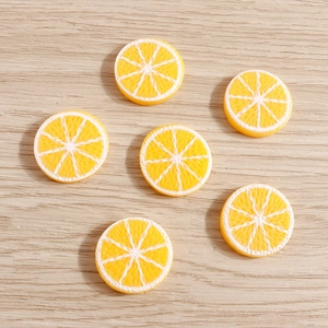 Detailed view of six yellow resin lemon slices for DIY crafts on light wood background