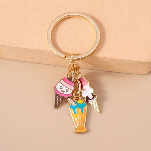 Détail de trois breloques en émail coloré en forme de glace et milkshake sur porte-clés doré