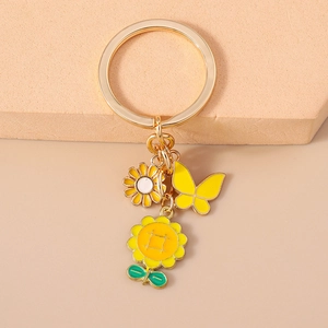 Vue détaillée des pendentifs tournesol et papillon sur un porte-clés doré élégant