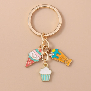 Détail de pendentifs glace, cupcake et milkshake sur un porte-clés en métal doré