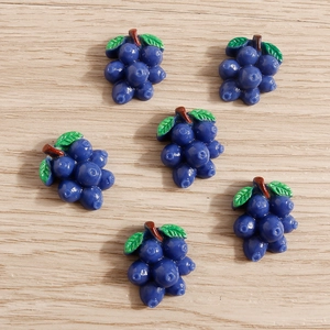 Detailed macro view of resin grape and blueberry charms for DIY crafts and phone cases