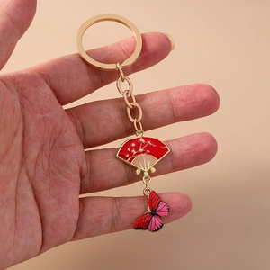 Detail showing Chinese style red fan and butterfly keychain with gold enamel finish