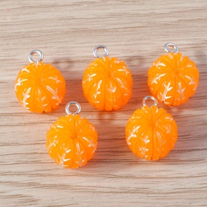 Detailed view of orange resin fruit pendants with silver rings for DIY jewelry projects