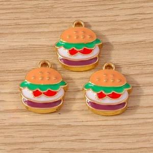 Detailed view of DIY burger charms with colorful enamel layers on a light wood background