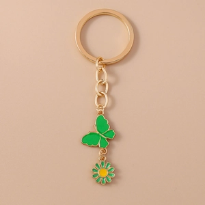 Vue détaillée du papillon émeraude et de la marguerite sur un porte-clés doré