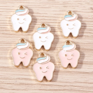 Macro detail of cartoon tooth enamel pendants with gold alloy plating for DIY crafts