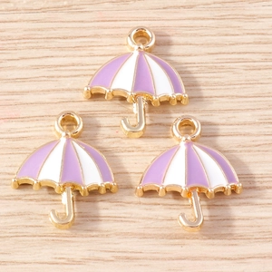 Detail of three purple and white striped umbrella pendants with gold-plated metal frames