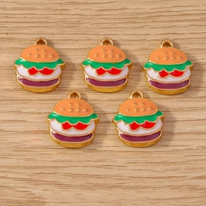 Detailed view of five burger-shaped enamel charms on a natural light wood background