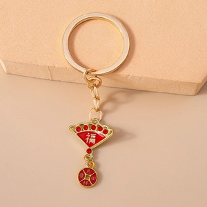 Detailed close-up of a golden Chinese fan keychain with red rhinestones and Fu character