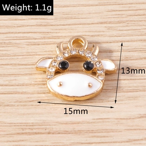 Macro detail of cow charm with white enamel and rhinestones showing 15mm width size