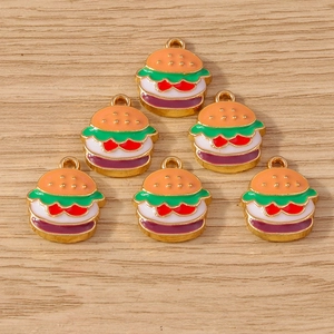 Detailed view of layered hamburger charms for DIY jewelry making on wooden background