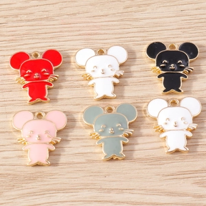 Detail of colorful enamel mouse charms with light gold bases on a wood background