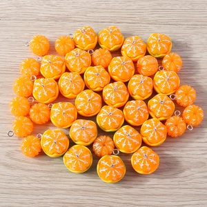 Macro detail of realistic resin orange charms with silver rings on wood background