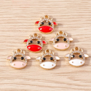 Flat lay of six colorful cow charms with gold alloy bases and sparkling white rhinestones