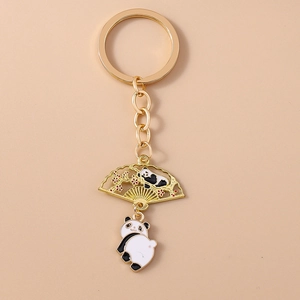 Detail of golden panda keychain with fan pendant and traditional plum blossom motifs