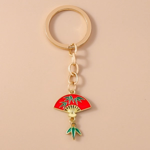 Detail of a Chinese style fan keychain with red enamel and green bamboo leaf charms