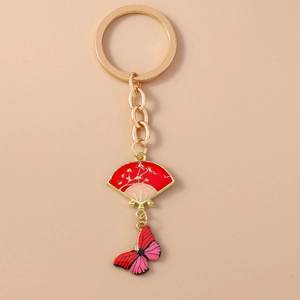 Detail of a Chinese-style gold keychain with red fan and butterfly enamel pendants