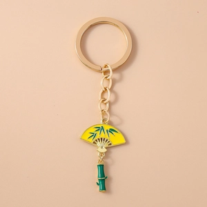 Detail of Chinese style keychain with golden chain, yellow fan pendant, and green bamboo charm