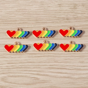 Close-up of rainbow gradient heart enamel charms with gold alloy edges for DIY jewelry