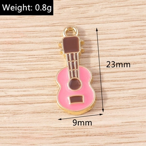 Macro detail of a 23mm pink enamel guitar charm with size measurements for DIY jewelry