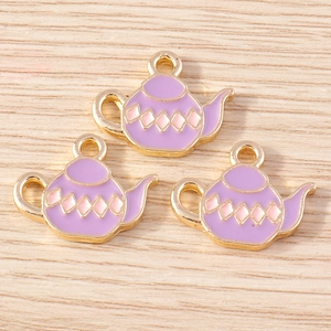 Detailed macro view of purple enamel teapot charms with pink patterns for DIY jewelry