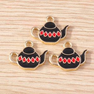 Macro detail of three black and red enamel teapot pendants with golden metal edges