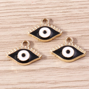 Vue détaillée de trois pendentifs œil maléfique dorés en émail pour la création de bijoux