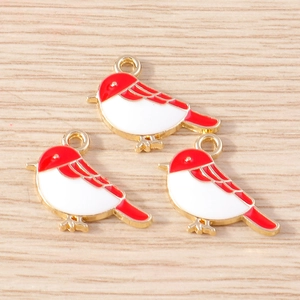 Detailed macro view of three red and white enamel bird pendants with golden alloy edges