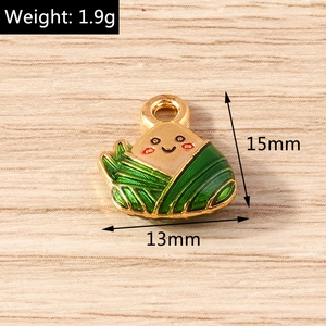 Makroaufnahme eines 15mm lächelnden Zongzi-Anhängers aus grünem Emaille und Goldring