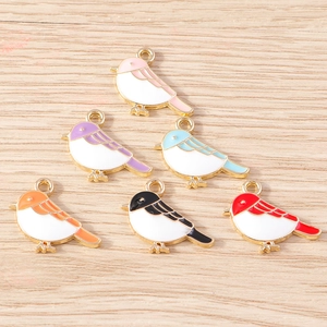 Detailed close-up of six colorful bird-shaped enamel charms for DIY jewelry making