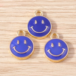 Detailed macro view of three blue enamel smiley face charms with gold metallic edges