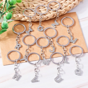 Macro detail of rhinestone-encrusted silver letter keychains in a stylish arrangement