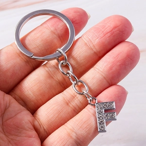 Detailed macro view of the silver alloy letter F keychain charm encrusted with rhinestones