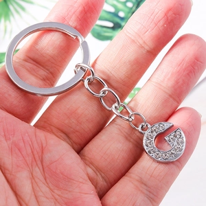 Close-up of a silver letter G keychain with sparkling rhinestones on short chain