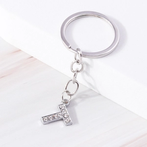Detail of silver metal keychain letter T pendant with sparkling inlaid crystals