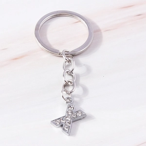 Macro shot of a sparkling silver metal letter X keychain with clear crystal rhinestones