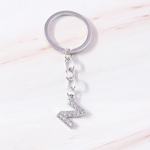 Macro detail of silver-toned metal letter N keychain inlaid with sparkling rhinestones