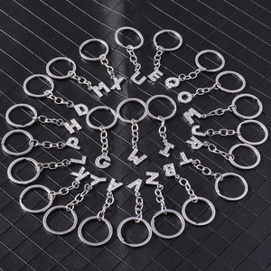 Sparkling silver alphabet keychains with white rhinestones arranged in a circular display