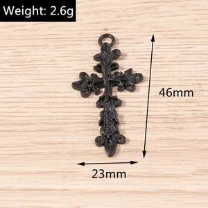 Vue macro du pendentif croix rétro noire de 46mm avec des gravures florales
