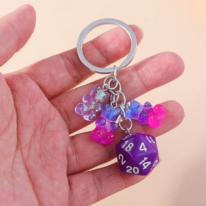 Detailed macro of gradient resin bear charms and a purple D20 dice keychain accessory