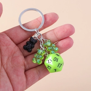 Close-up of cute black and green resin bear charms with a neon D20 dice keychain