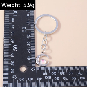 Futuristic silver crescent moon keychain with rhinestones and iridescent bead, 5.9g weight