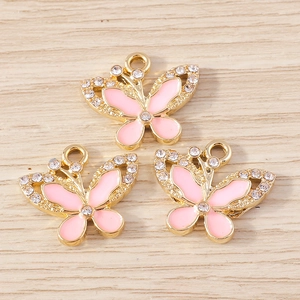 Dettaglio di ciondoli a farfalla con smalto rosa e strass lucidi per la creazione di gioielli