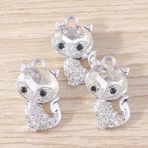 Close-up of cute cartoon fox jewelry charms with sparkling crystals and silver plating