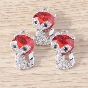 Close-up of DIY fox pendants with red gems and sparkling rhinestones for jewelry making
