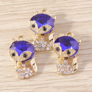 Detailed view of fox pendant charms with blue gemstone and sparkling white rhinestones