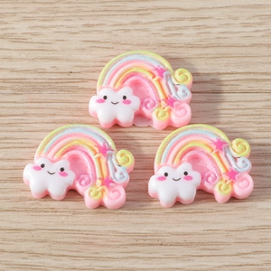 Cute resin rainbow and cloud DIY pendants in pastel colors on a wooden surface