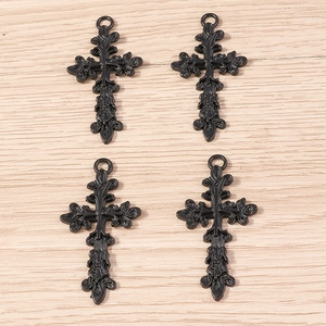 Lot de quatre pendentifs croix gothiques noirs en alliage avec filigrane sur fond bois