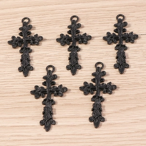Détail de cinq pendentifs croix gothiques noires avec filigrane complexe et anneaux de suspension