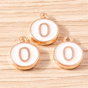 Detailed macro view of three rose gold number 0 alloy pendants with white enamel on wood